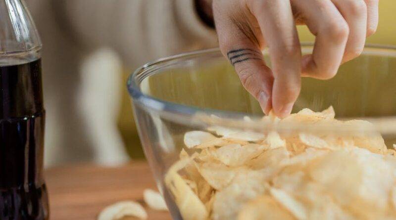 person getting delicious potato chips in a bowl